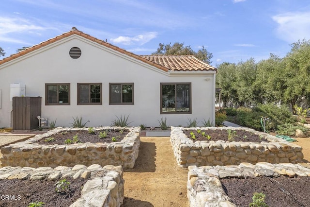 view of front facade with a tiled roof and stucco siding