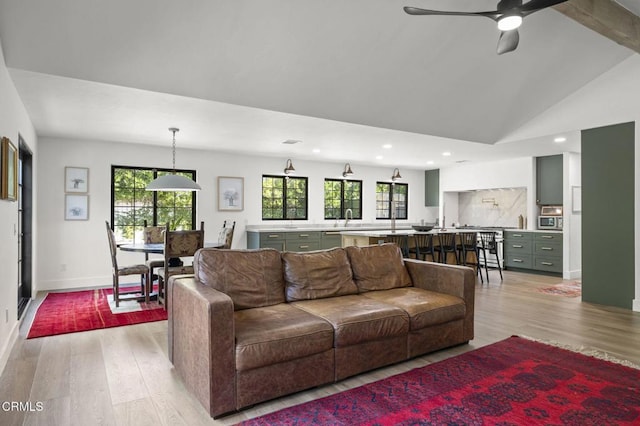 living room with vaulted ceiling, light wood-type flooring, baseboards, and recessed lighting