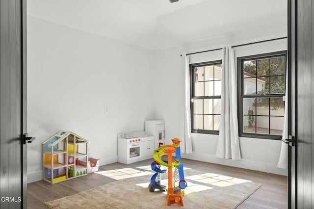 playroom with light wood-type flooring and baseboards