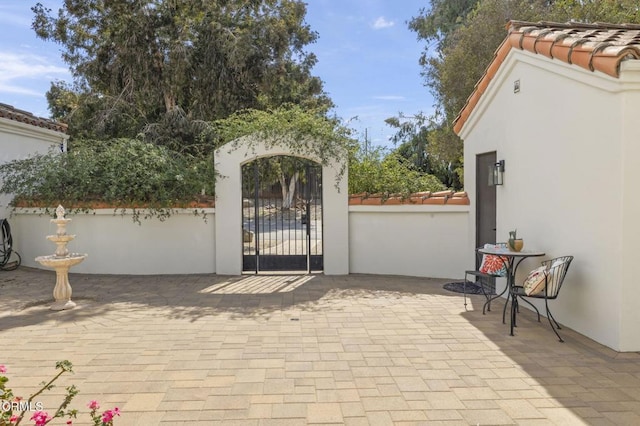 view of gate with a patio and fence