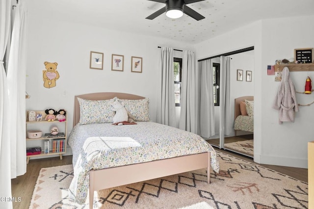 bedroom featuring ceiling fan, baseboards, and wood finished floors