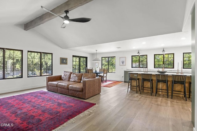 living room featuring vaulted ceiling with beams, recessed lighting, light wood-style floors, ceiling fan, and baseboards