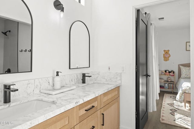 bathroom with double vanity, visible vents, a sink, and ensuite bathroom