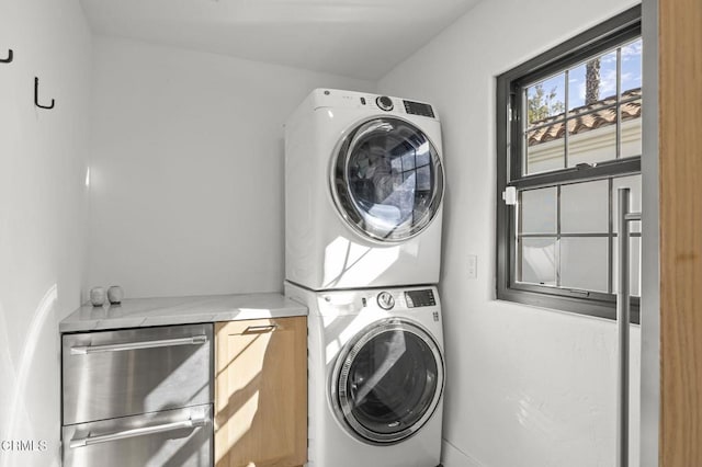 laundry room with stacked washing maching and dryer and laundry area