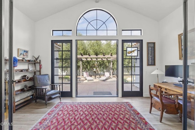 doorway to outside with lofted ceiling and wood finished floors