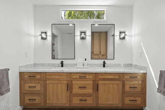 bathroom with baseboards, a sink, and double vanity