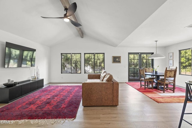 living area featuring baseboards, wood finished floors, lofted ceiling with beams, and ceiling fan