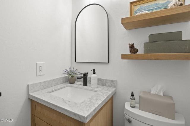 half bathroom with vanity and toilet