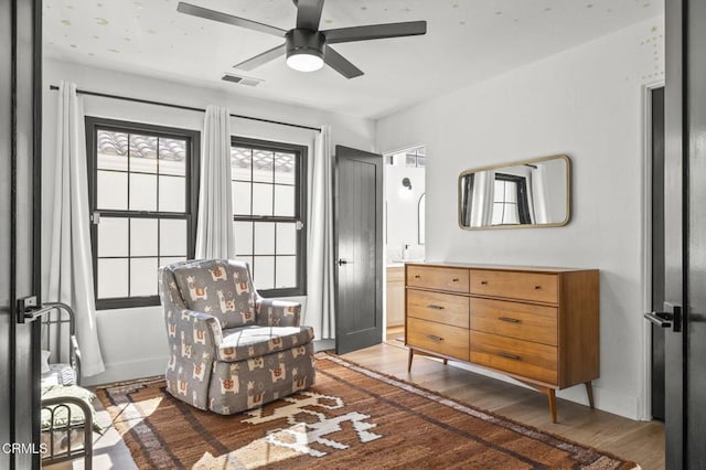 sitting room featuring wood finished floors, visible vents, and ceiling fan