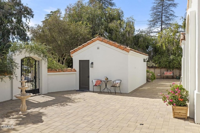 view of outbuilding with a gate, fence, and an outbuilding