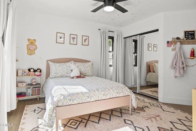 bedroom with baseboards, a ceiling fan, and wood finished floors