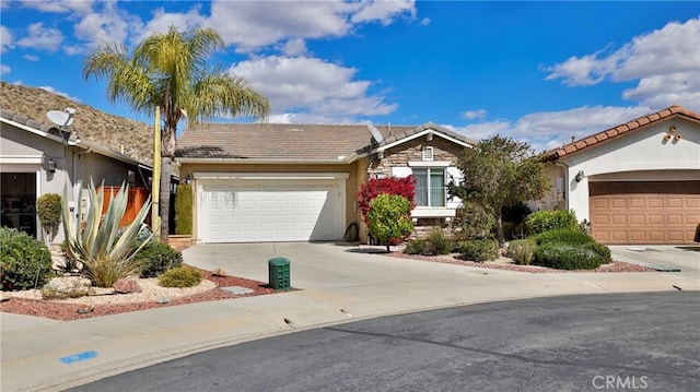 view of front facade featuring a tiled roof, concrete driveway, and an attached garage