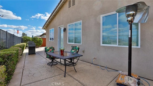 view of patio with fence, area for grilling, and outdoor dining space