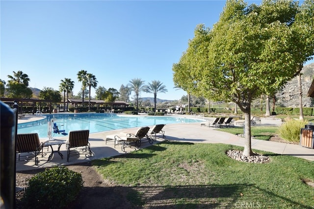 community pool featuring a patio and a yard