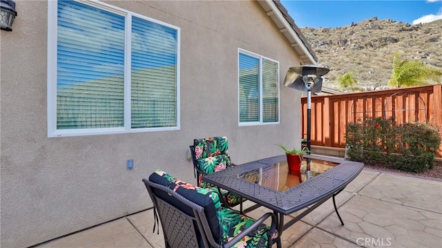 view of patio featuring outdoor dining space and fence