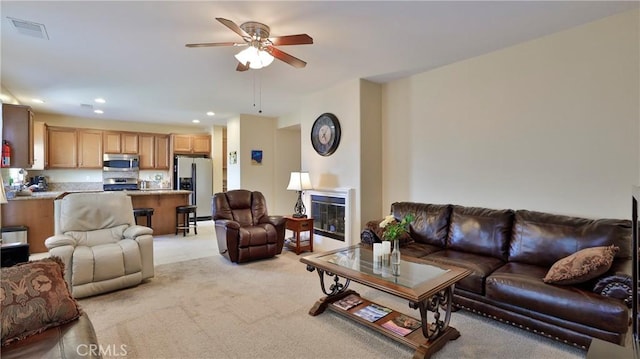 living room with ceiling fan, recessed lighting, light carpet, visible vents, and a glass covered fireplace