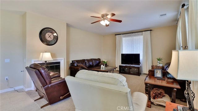 living area featuring ceiling fan, visible vents, and baseboards