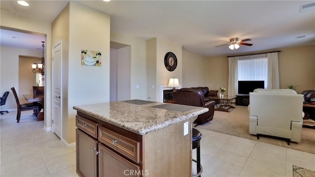 kitchen featuring a breakfast bar, light tile patterned flooring, visible vents, and a center island