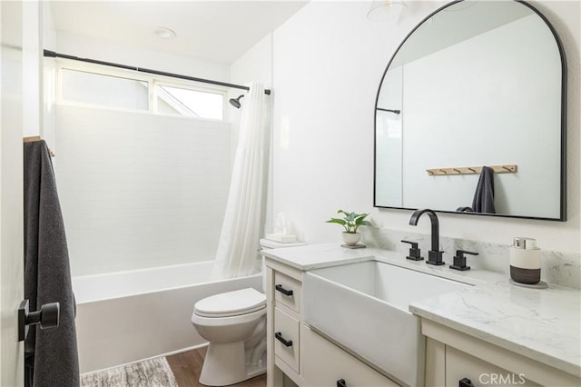 bathroom with vanity, toilet, wood finished floors, and shower / tub combo with curtain