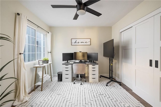 office area with ceiling fan and baseboards