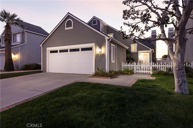 view of front of house with a yard, concrete driveway, an attached garage, and fence