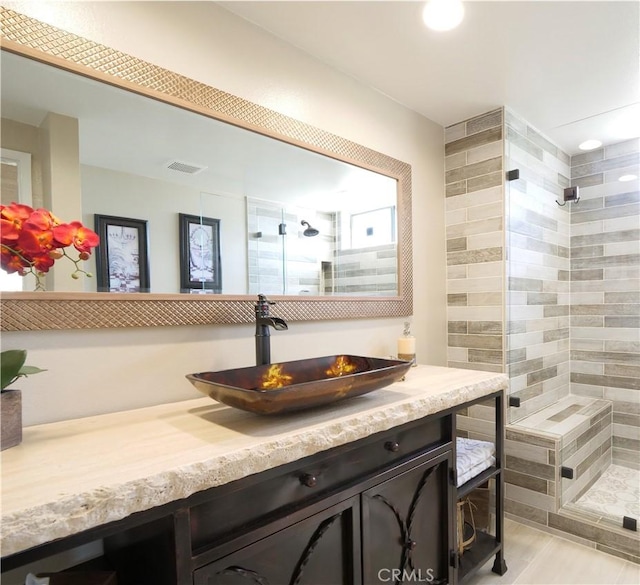 full bath featuring a stall shower, visible vents, and vanity