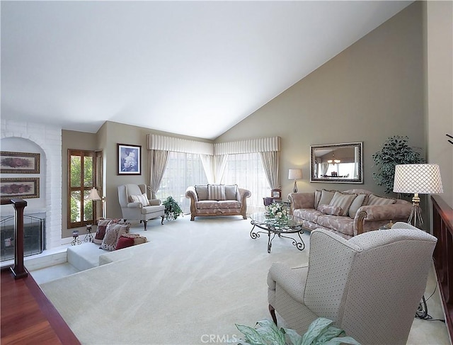 carpeted living area featuring high vaulted ceiling and a fireplace