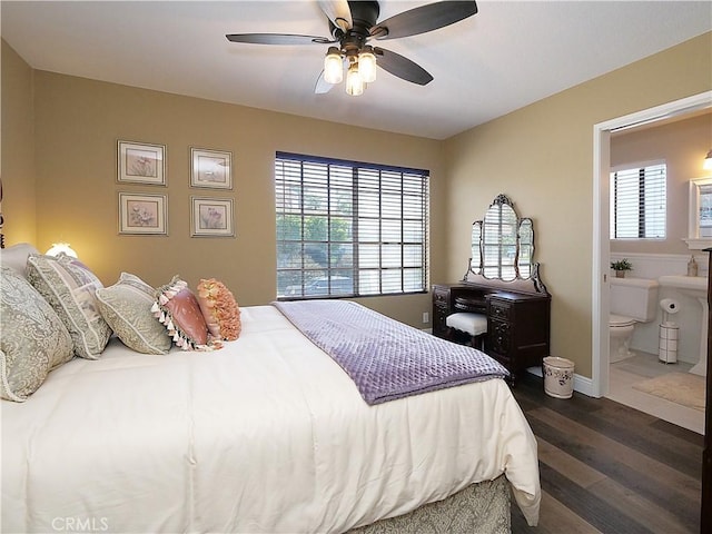 bedroom with dark wood-style flooring, multiple windows, ensuite bath, and a ceiling fan