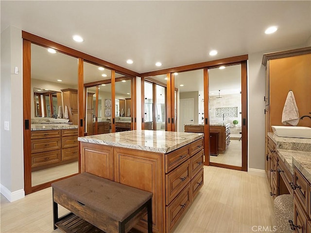 spacious closet with light wood finished floors and a sink