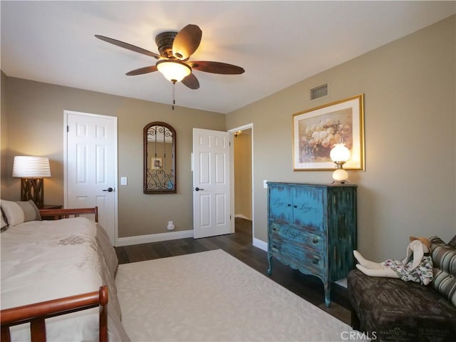 bedroom with baseboards, ceiling fan, visible vents, and dark wood-type flooring