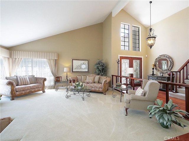 carpeted living area featuring stairway, an inviting chandelier, french doors, high vaulted ceiling, and beam ceiling