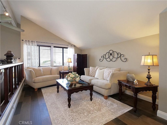 living area featuring vaulted ceiling, dark wood finished floors, and baseboards