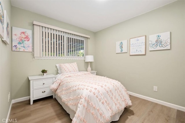 bedroom with wood finished floors and baseboards