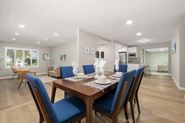 dining area featuring light wood finished floors, baseboards, and recessed lighting