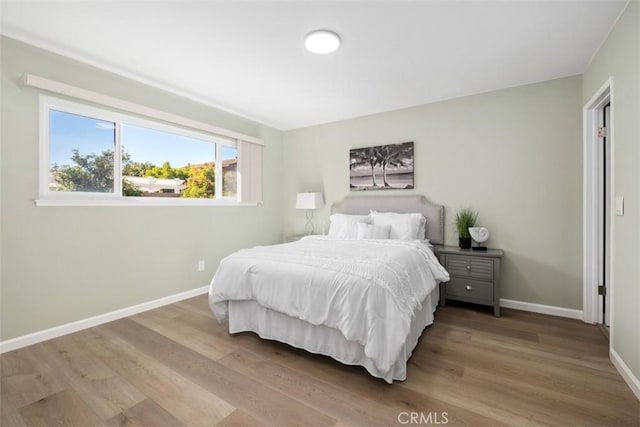 bedroom with wood finished floors and baseboards