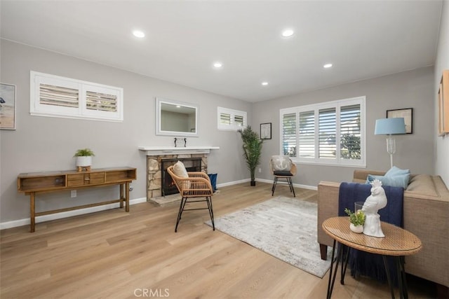 sitting room featuring light wood-type flooring, a fireplace, baseboards, and recessed lighting