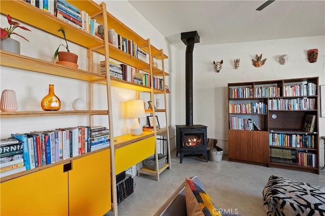 living area featuring a wood stove and concrete floors