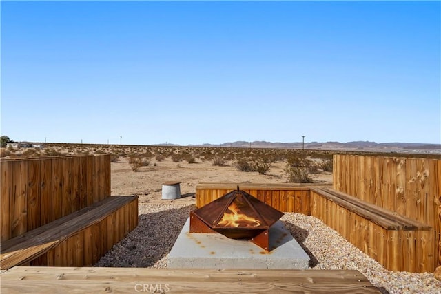 view of yard featuring an outdoor fire pit and a mountain view