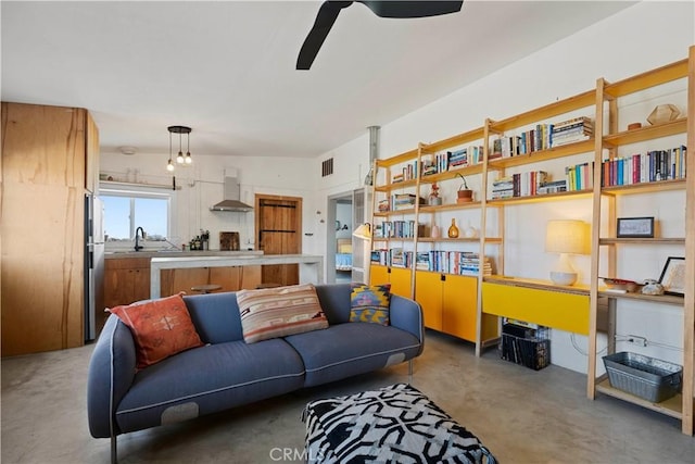 living area featuring a ceiling fan, visible vents, and concrete flooring