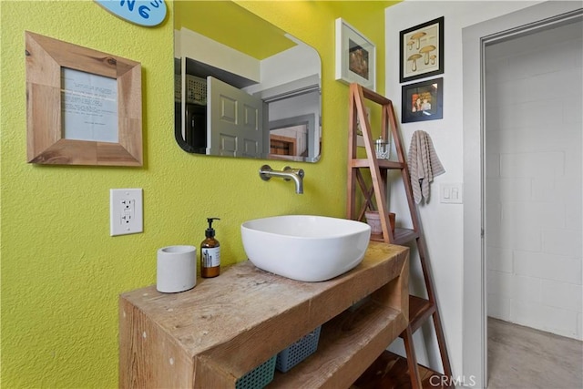 bathroom featuring a textured wall and vanity