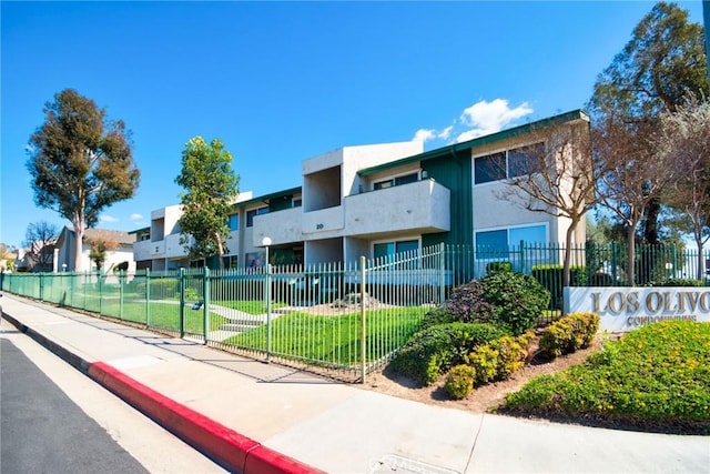 view of building exterior with a fenced front yard and a residential view