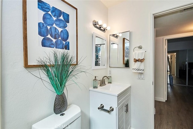 bathroom with visible vents, toilet, wood finished floors, and vanity