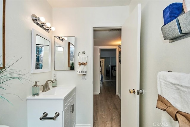 bathroom with wood finished floors, vanity, and baseboards