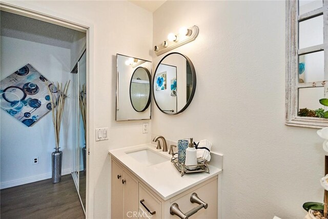 bathroom with vanity, baseboards, and wood finished floors