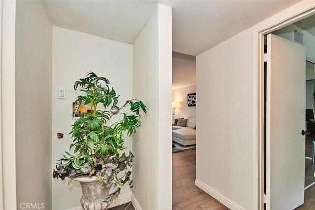 hall with baseboards and wood finished floors