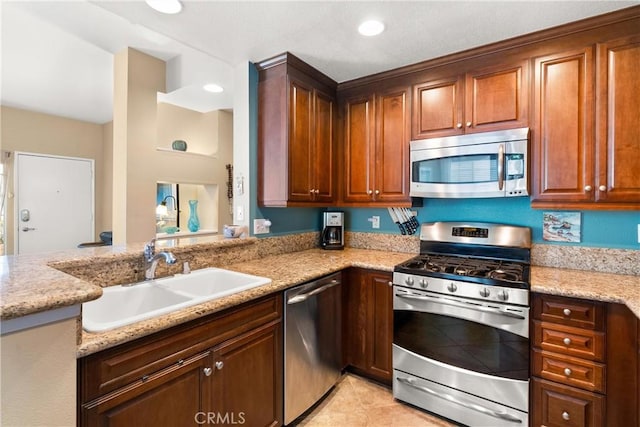 kitchen with light tile patterned flooring, recessed lighting, stainless steel appliances, a sink, and light stone countertops