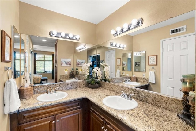 full bathroom featuring double vanity, visible vents, a sink, and ensuite bathroom