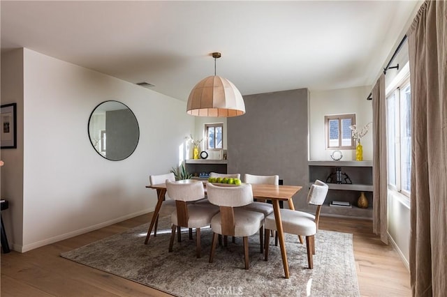 dining area featuring light wood-type flooring, visible vents, and baseboards