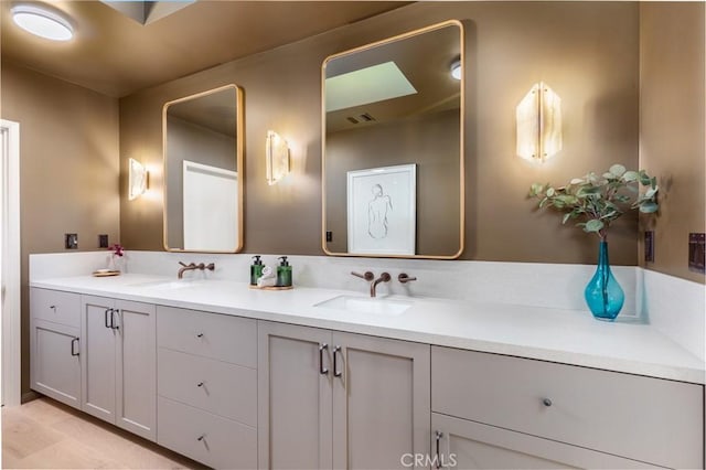 bathroom with visible vents, a sink, and double vanity