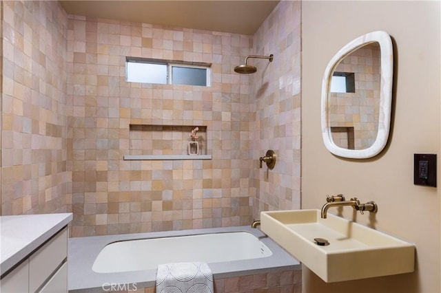 bathroom featuring a sink and tiled shower / bath